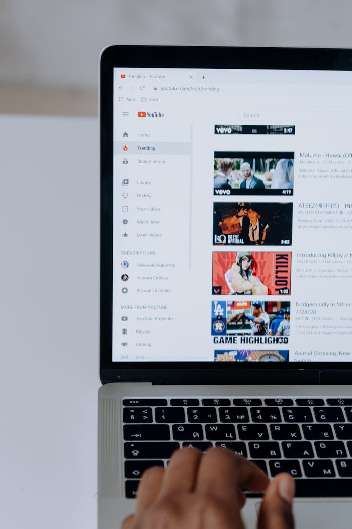 testimonial-image Person browsing YouTube videos on a laptop, showcasing modern technology and online content.